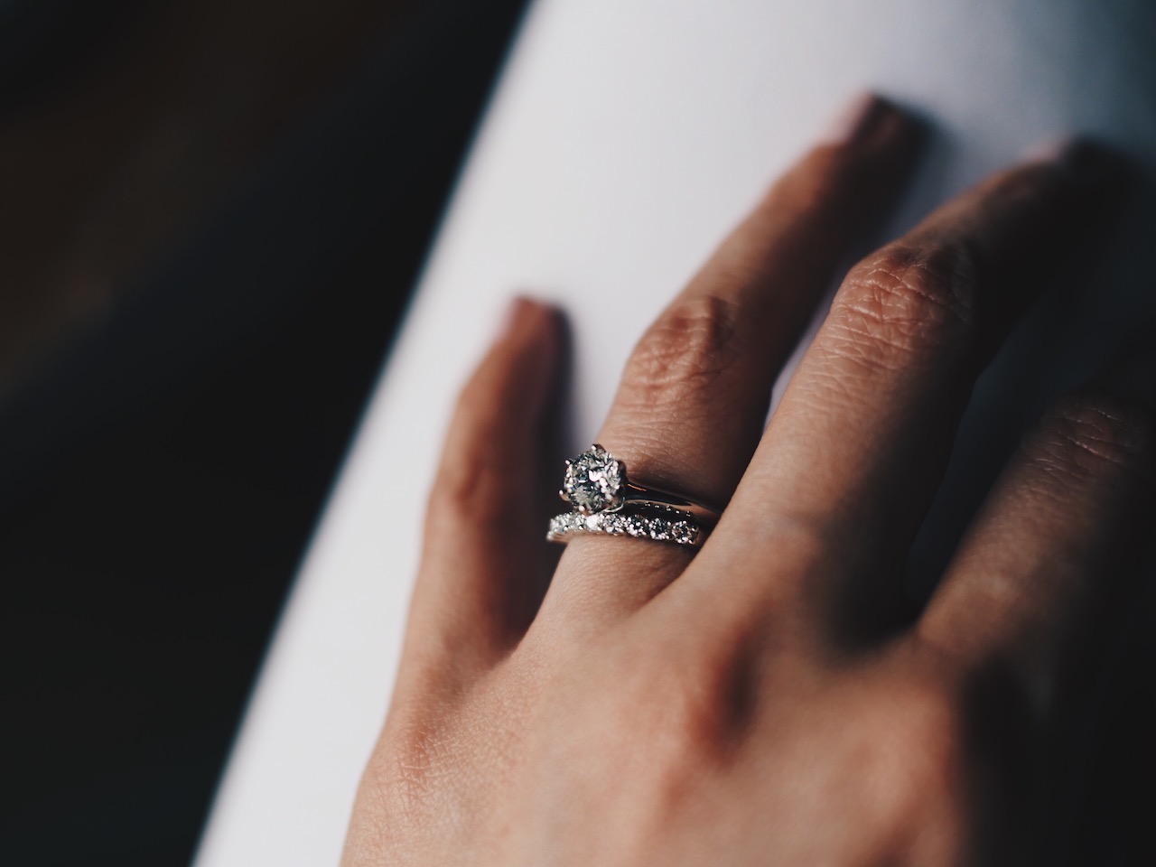 woman wearing both wedding band and engagement ring