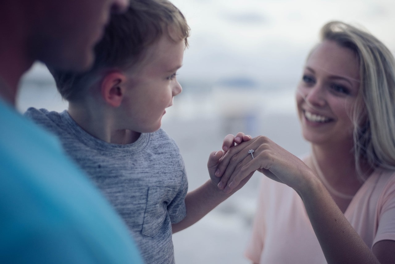 woman showing engagement ring to child